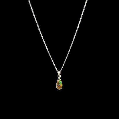 A natural, pear shaped Australian boulder opal with blue, purple, and green colors bezel set into a sterling silver necklace.