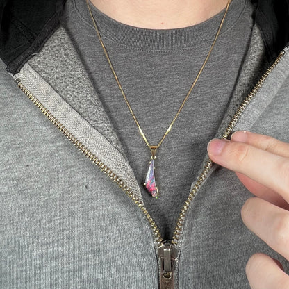 Close-up of person wearing red boulder opal necklace in 18k gold around neck