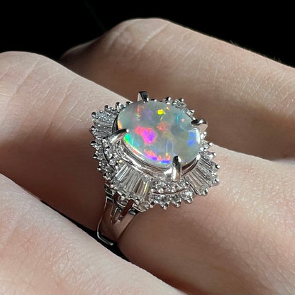 Close-up of a semi-black-opal and diamond ring, showcasing its vivid purple and red opal fire in a vintage platinum setting.