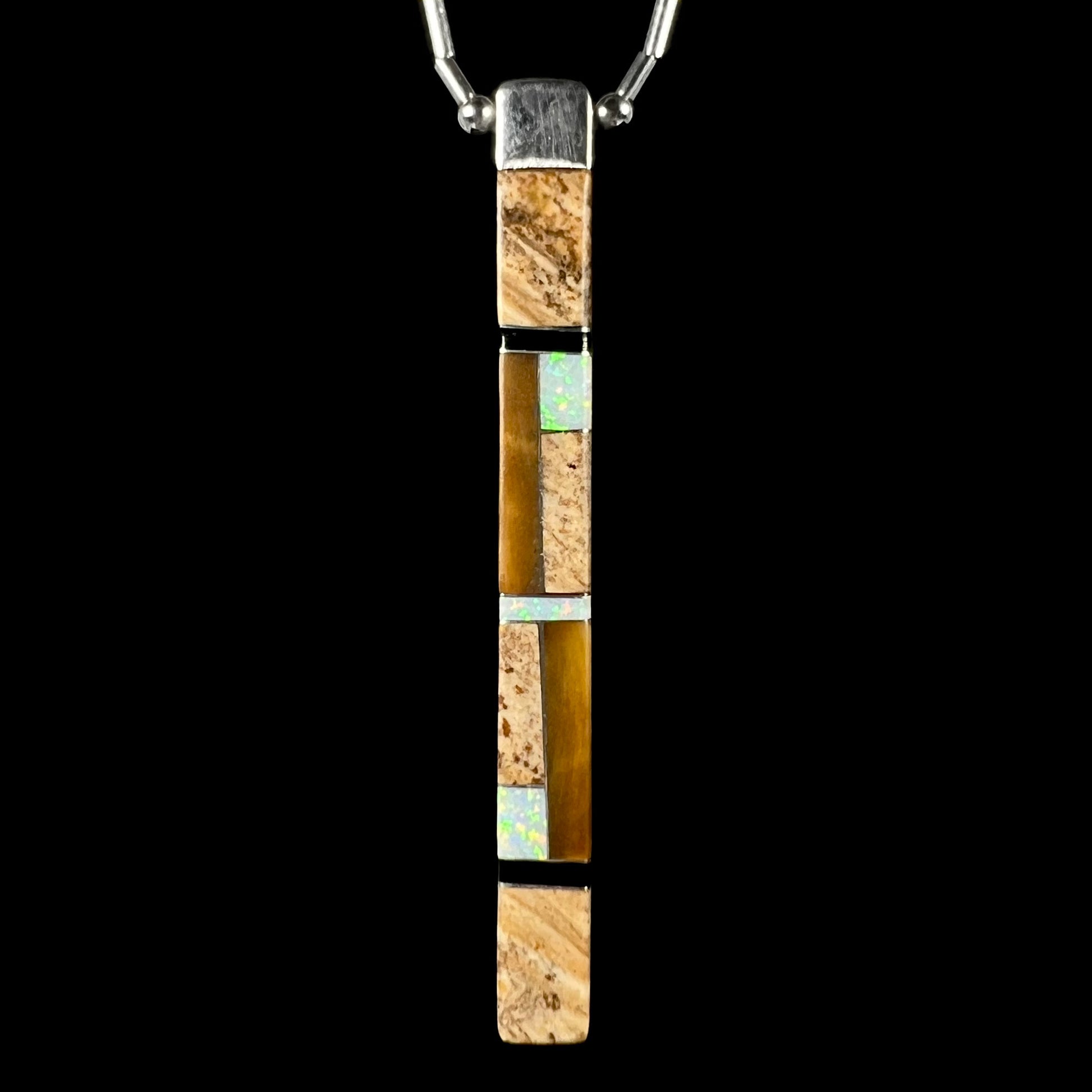 The reverse side of the Navajo inlay pendant, featuring picture jasper, tiger’s eye, white opal, and onyx inlay, against a black background.