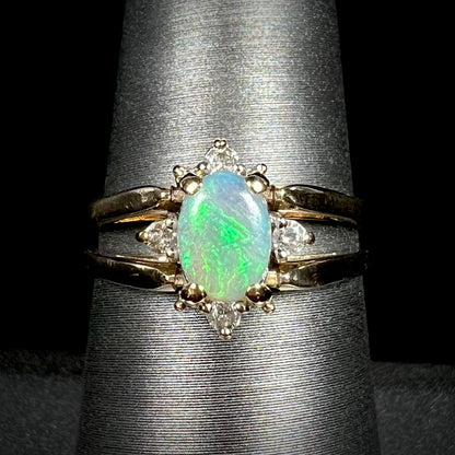 Close-up of women's 14k gold reversible green Australian opal and diamond flip ring on display