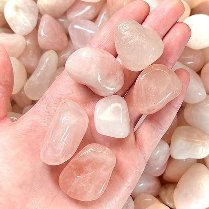 Pink, palm sized, tumble polished rose quartz stones.