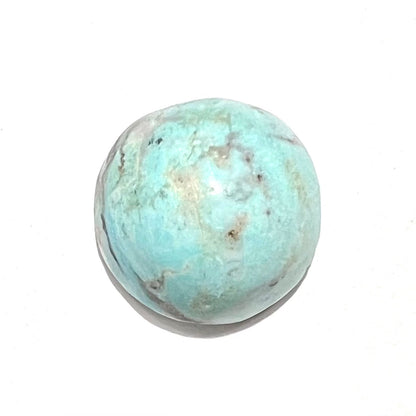 A loose, round cabochon cut Valley Blue turquoise stone.