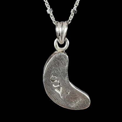 A sterling silver necklace bezel set with a natural Koroit boulder opal stone.  The stone is shaped like a crescent moon.
