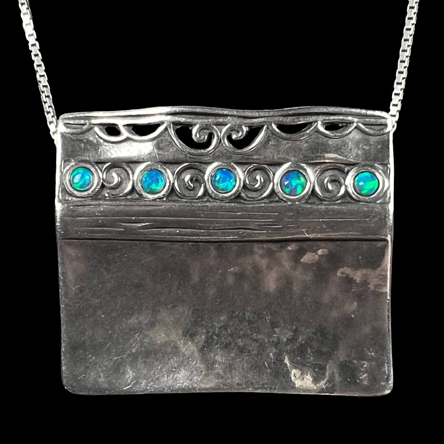 A handmade sterling silver five-stone opal necklace with a hammered finish by Israeli designer, Shablool Didae.