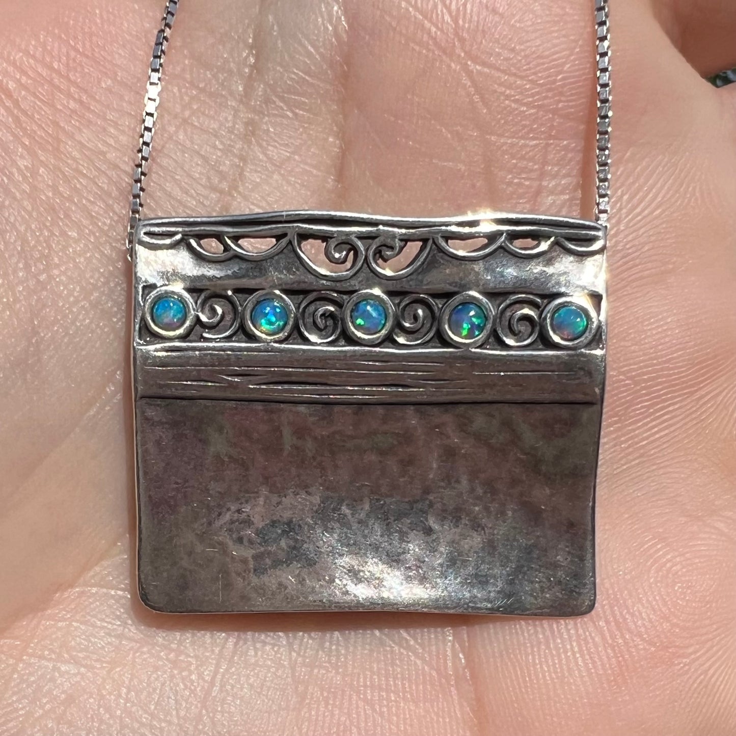 A handmade sterling silver five-stone opal necklace with a hammered finish by Israeli designer, Shablool Didae.