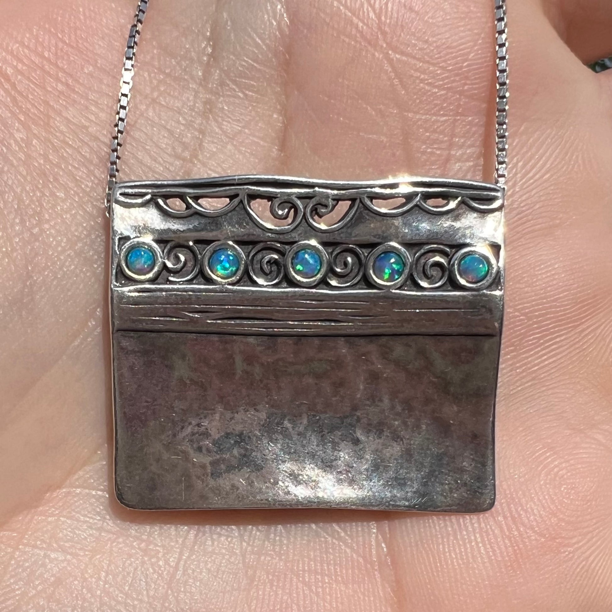 A handmade sterling silver five-stone opal necklace with a hammered finish by Israeli designer, Shablool Didae.