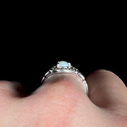 Side profile gallery view of a sterling silver Australian opal ring, worn on finger