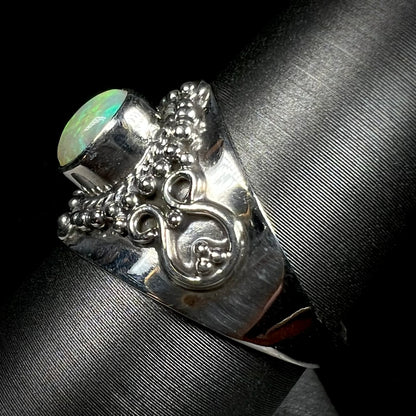 A silver boho opal ring shown from the side at a 90 degree angle.