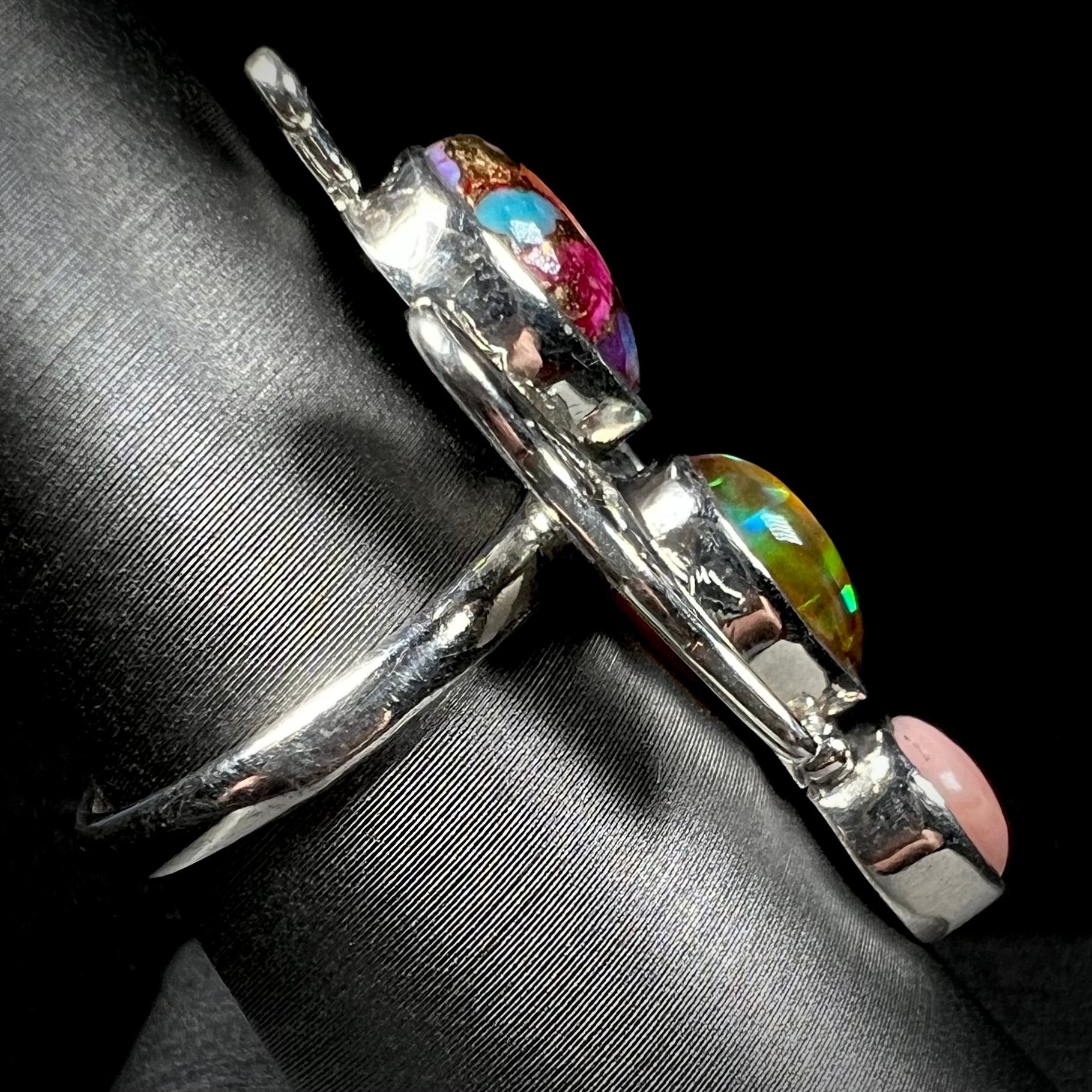 A sterling silver butterfly ring shown from the side.  The ring's handmade shank is in focus.