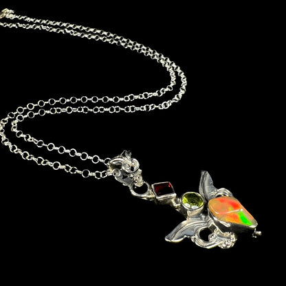 A sterling silver angel necklace set with an Ethiopian fire opal, peridot, and garnet.