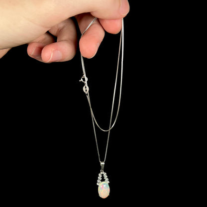 Hand dangling silver Ethiopian opal and cubic zirconia drop necklace from chain