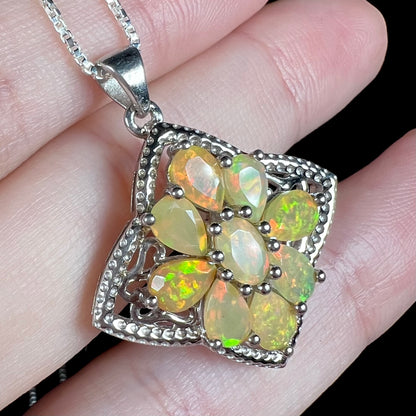 A sterling silver Ethiopian opal necklace shown at an angled view, held in a hand.