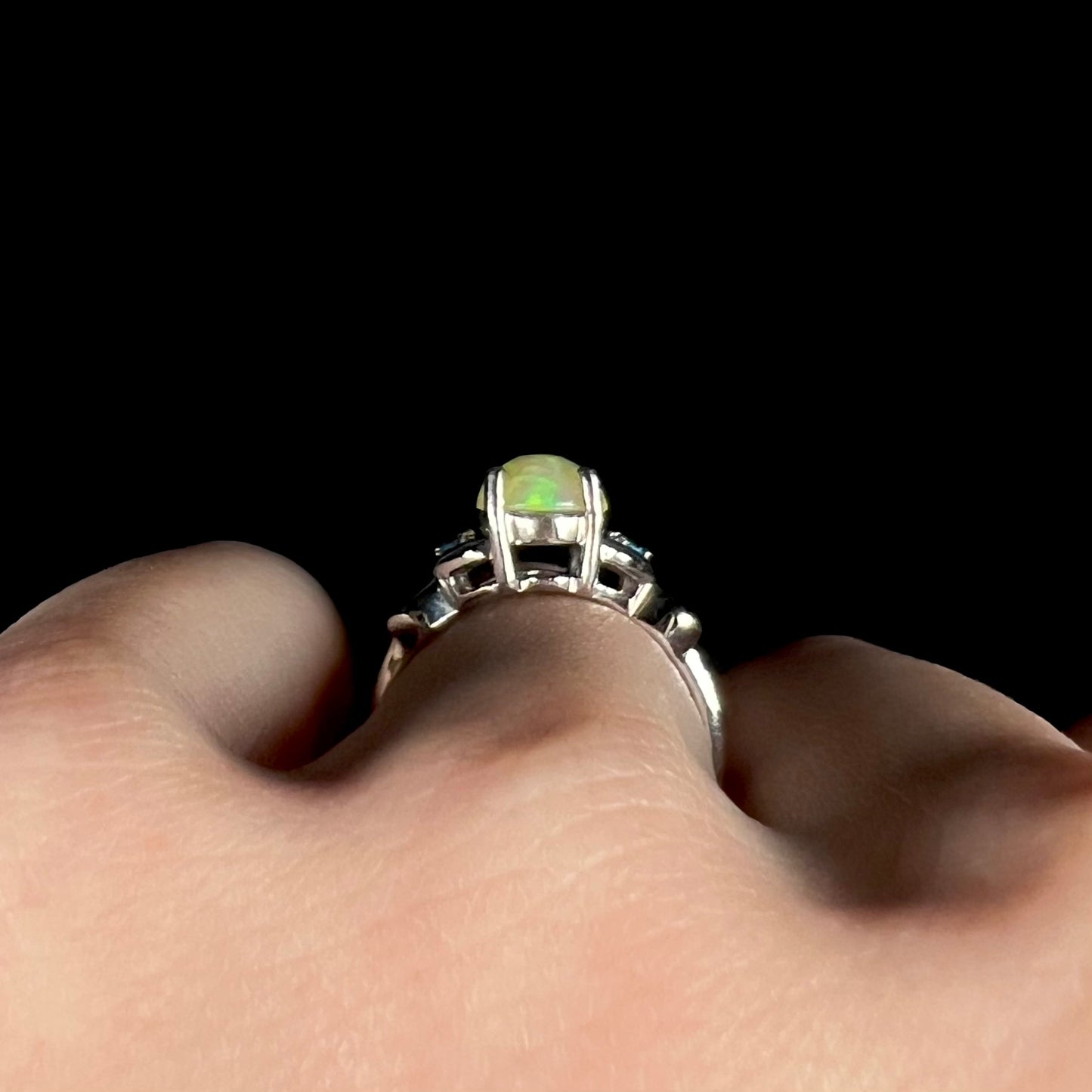 Side gallery profile view of Ethiopian opal ring in silver on finger