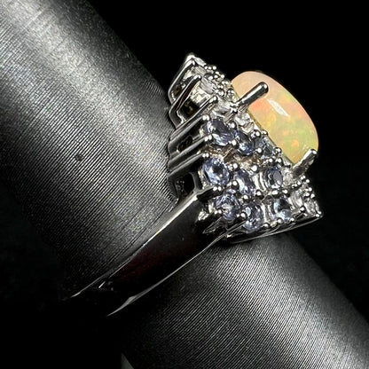 Sterling silver Ethiopian opal ring with tanzanite accents shown from the side view on ring display, focused on ring's shank