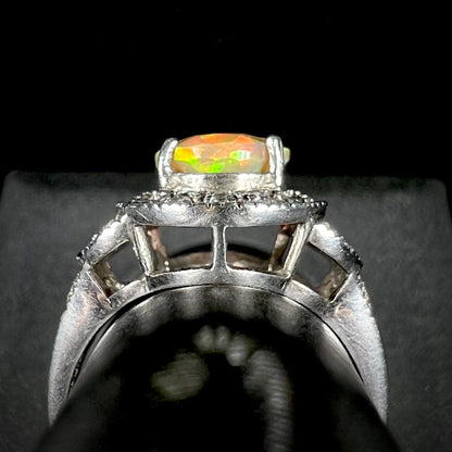 Side gallery profile view of a silver ring set with an Ethiopian opal against a black and gray background.
