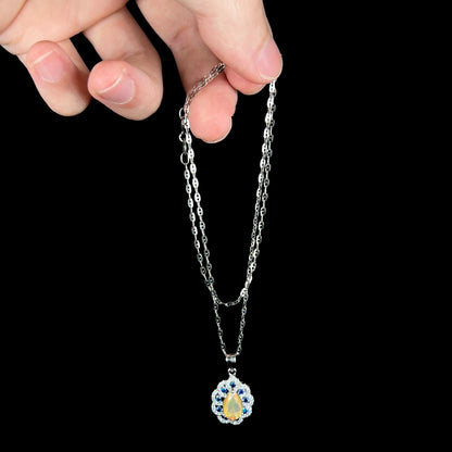 Hand dangling sterling silver Ethiopian opal and blue sapphire necklace from chain