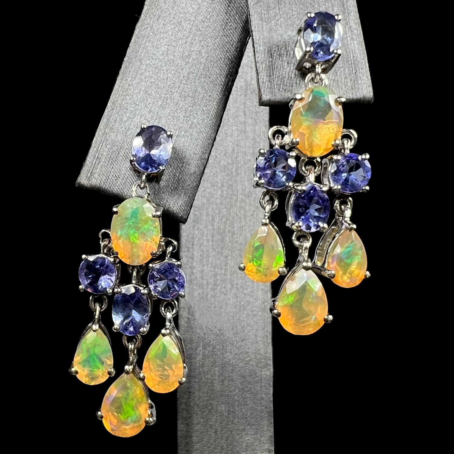 A pair of dangling sterling silver Ethiopian opal and tanzanite chandelier earrings, shown from the front.