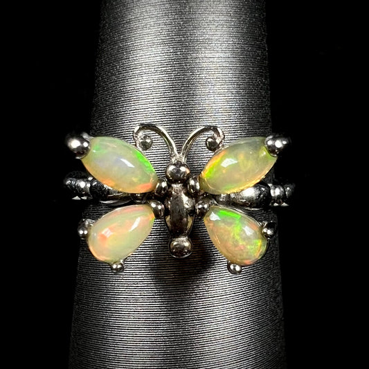 A sterling silver Ethiopian opal butterfly ring shown from the front on a ring display against a black background.
