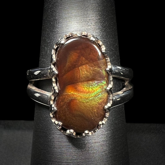 Sterling silver Mexican fire agate ring with a split shank shown from the front view against a black background.