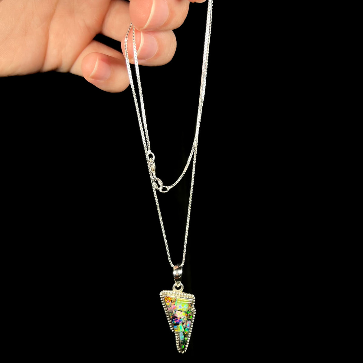 Hand dangling sterling silver mosaic opal necklace from box chain.