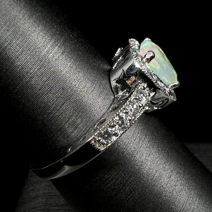 Side view of silver opal and pave set CZ ring on ring display, focusing on ring's shank and star-shaped cutout beneath ring's gallery