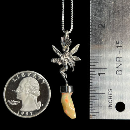 A 1.75" sterling silver fairy necklace with an Ethiopian fire opal crystal, shown next to a quarter coin and ruler.