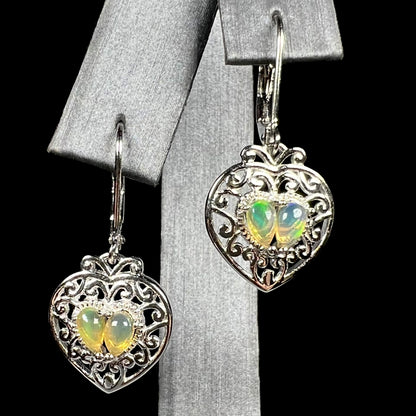 A pair of dangling sterling silver filigree heart earrings, each set with two Ethiopian opals.