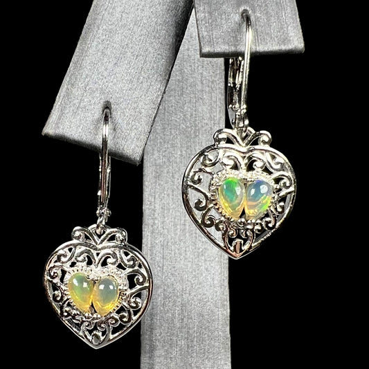 A pair of dangling sterling silver filigree heart earrings, each set with two Ethiopian opals.