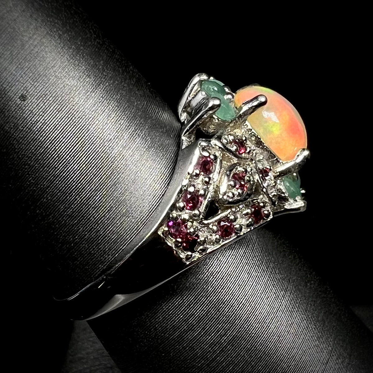 Side view of silver fire opal and garnet ring on ring display