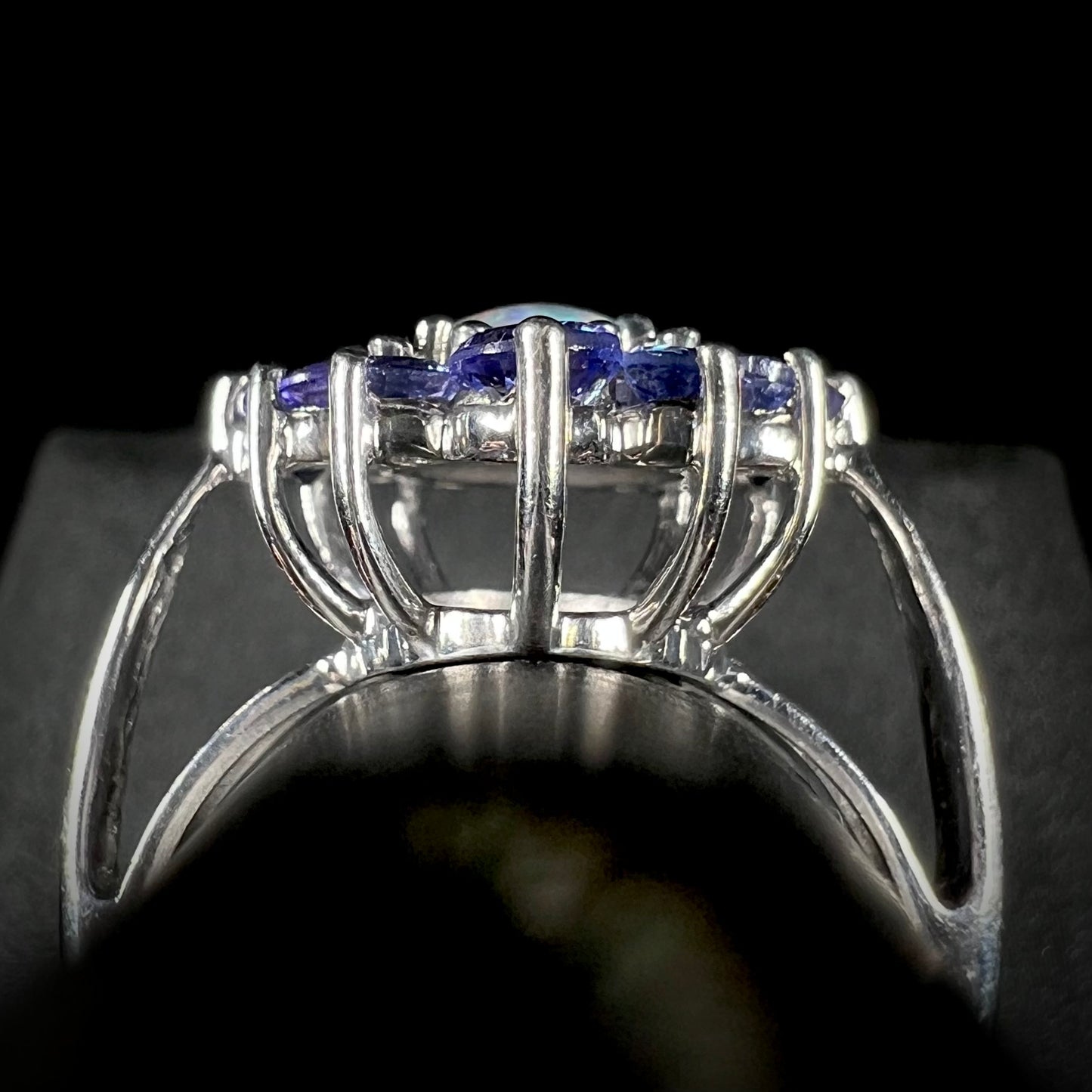 The gallery view of a silver tanzanite halo ring.  The center stone is a black opal triplet.