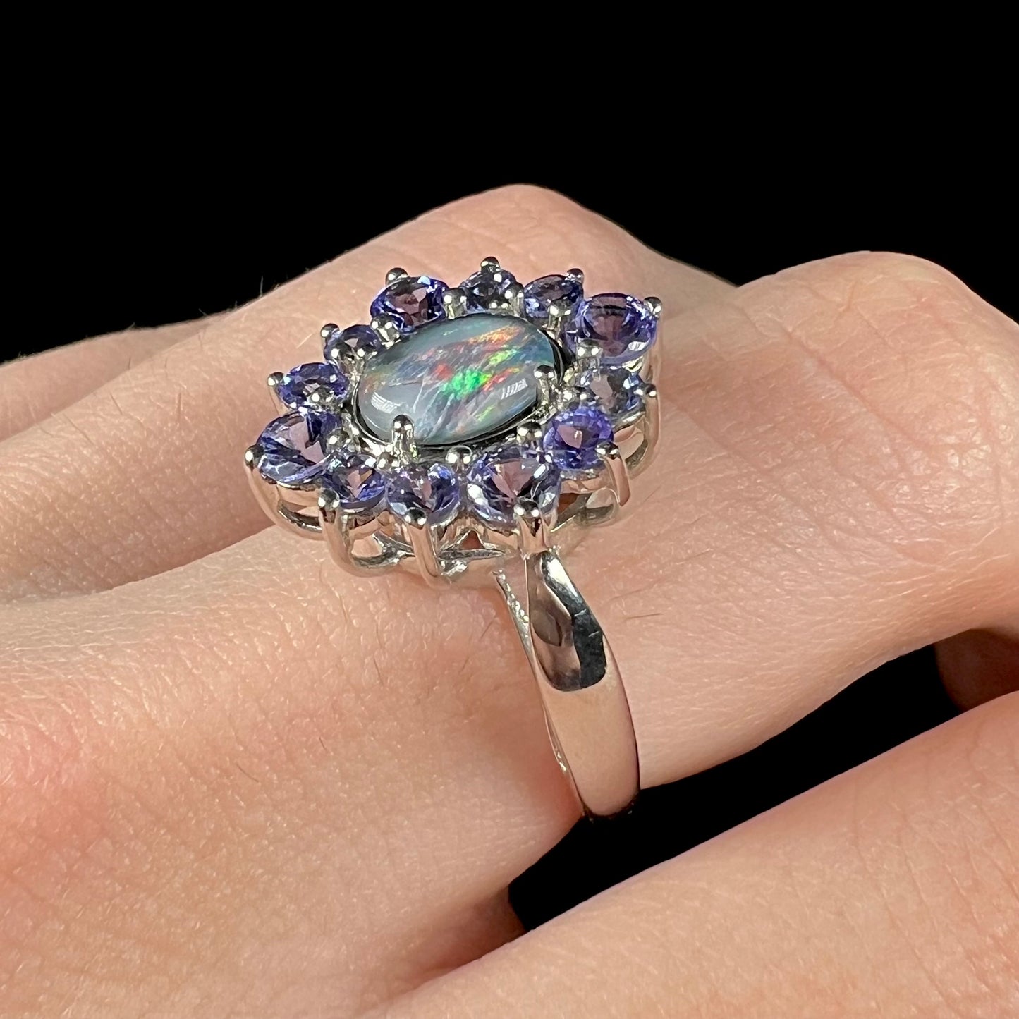 A sterling silver floating-style ring mounted with a black opal triplet in a halo of tanzanite stones.