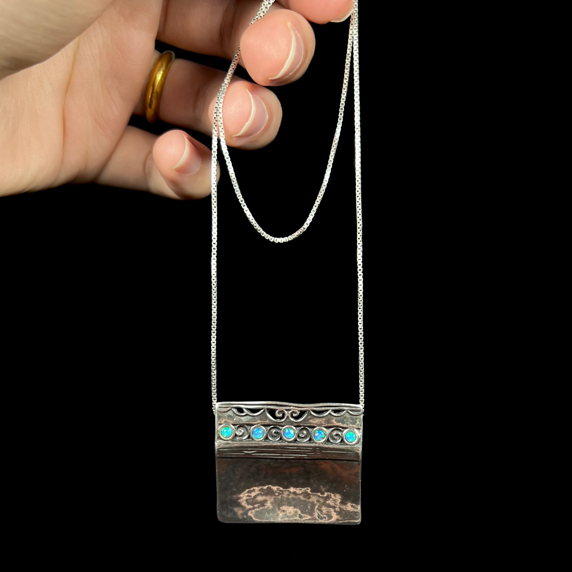 A handmade sterling silver five-stone opal necklace with a hammered finish by Israeli designer, Shablool Didae.