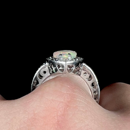 Side profile gallery view of sterling silver opal ring worn on finger, showing cutout heart, star, and crescent moon shapes along ring's gallery and shank