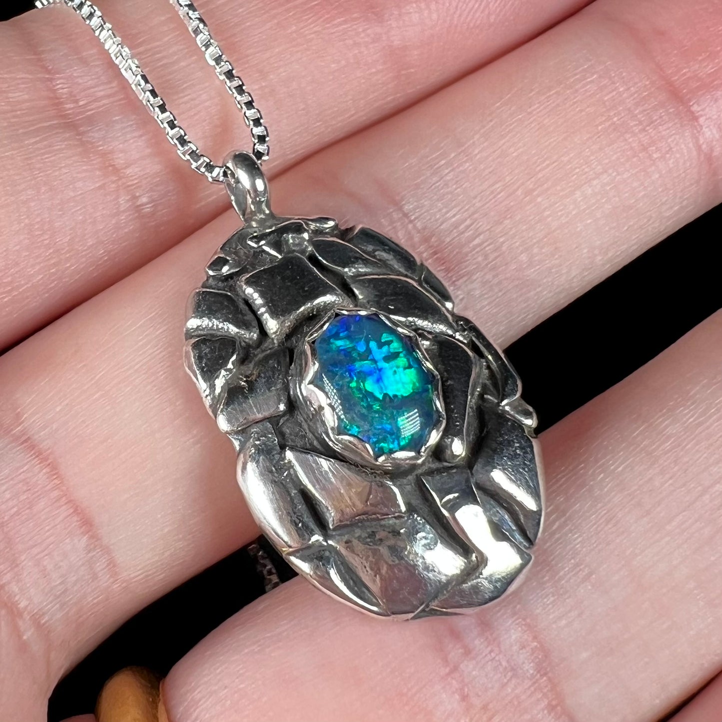 A unisex sterling silver pinecone-inspired opal triplet necklace.