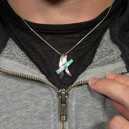 A folded design sterling silver turquoise and lab-created opal inlay necklace worn around a neck.