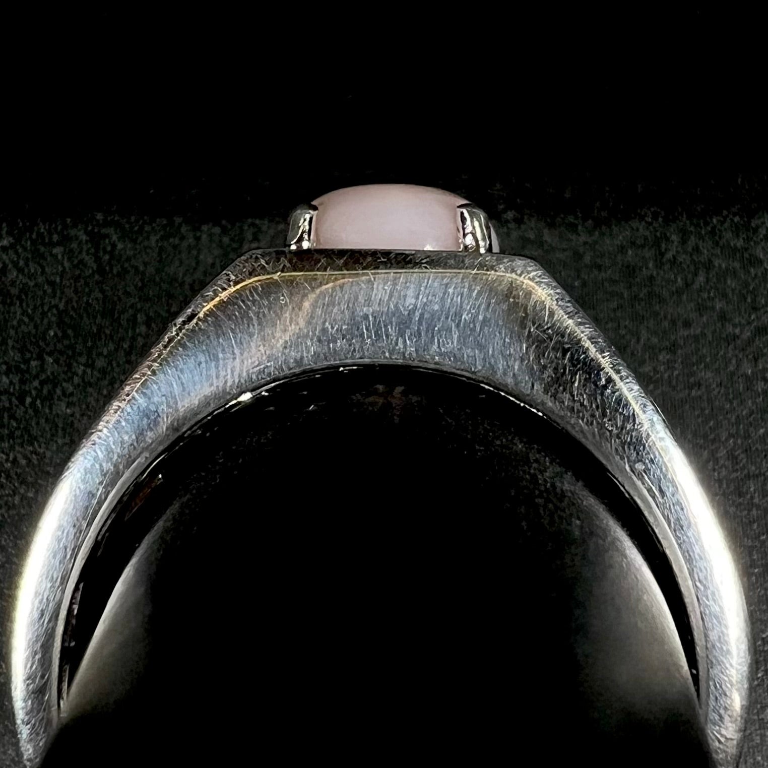 Side profile gallery view of sterling silver men's ring with pink opal on ring display
