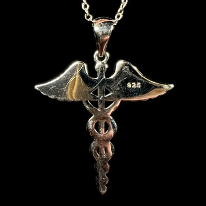 Back of a scratched silver plated medical caduceus pendant stamped "925".