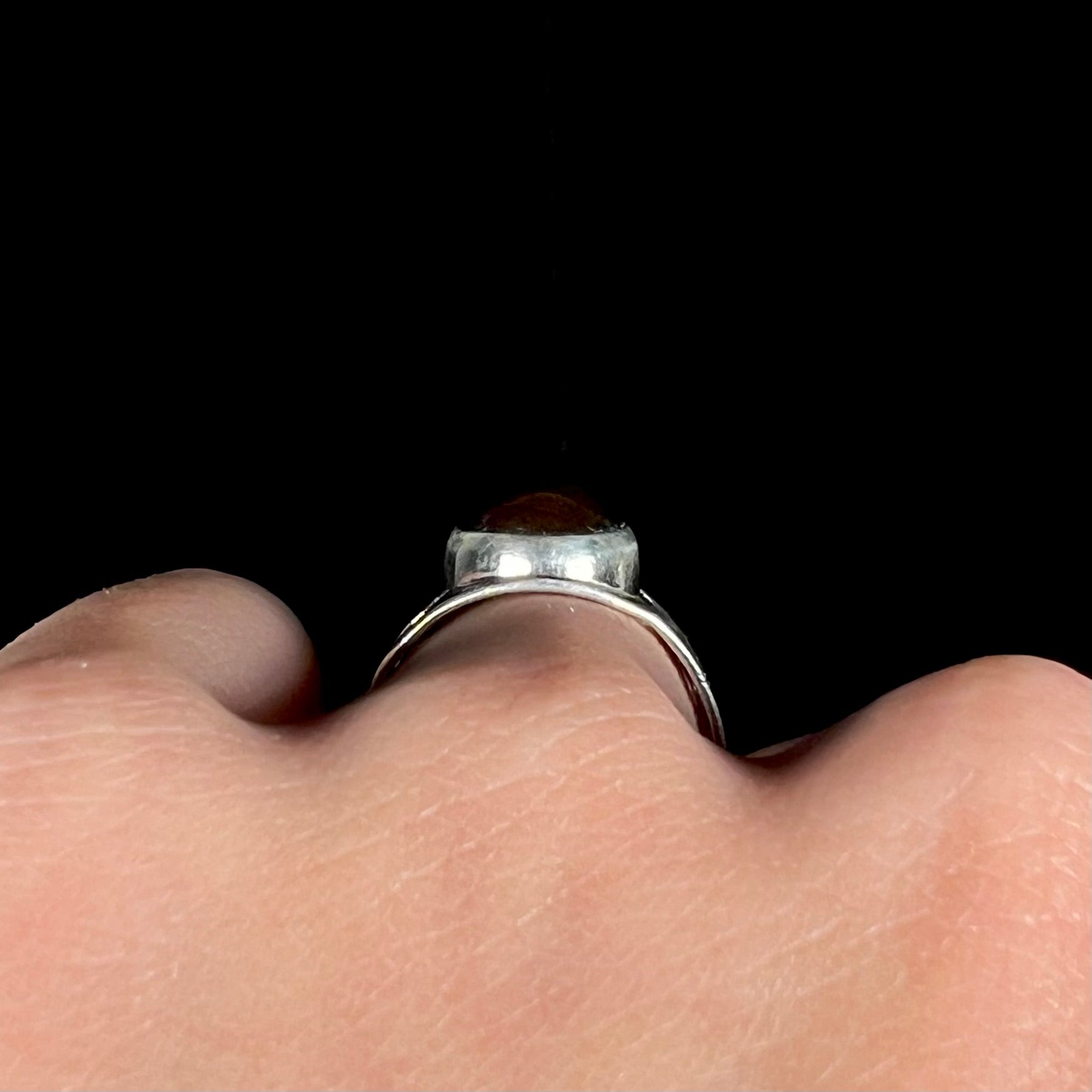 Side profile gallery view of a sterling silver ring, worn on a hand.
