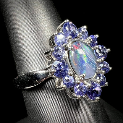 A sterling silver floating-style ring mounted with a black opal triplet in a halo of tanzanite stones.