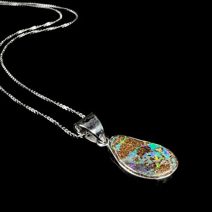 A sterling silver pendant set with an Australian boulder opal on a silver box chain.