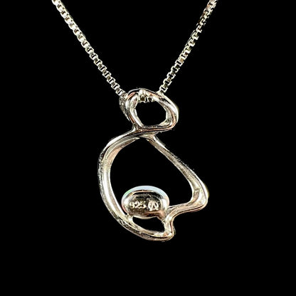 A ladies' sterling silver necklace set with an oval cabochon cut natural white crystal opal with green fire.
