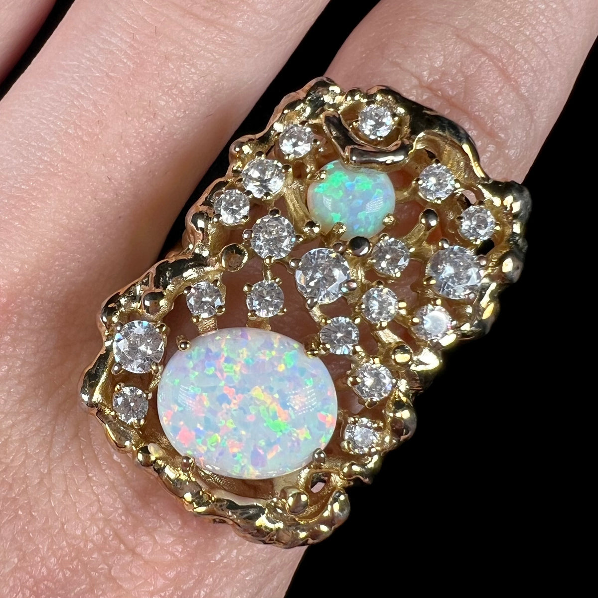 Close-up of size 11 men's synthetic opal and CZ bird's nest ring, worn on finger.