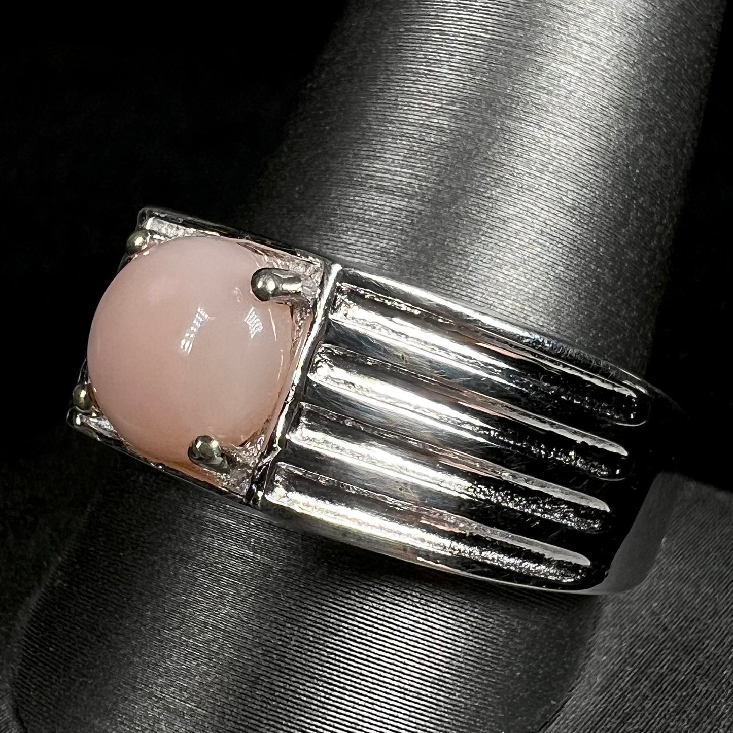 Close-up of size 12 pink opal men's ring in sterling silver on ring display