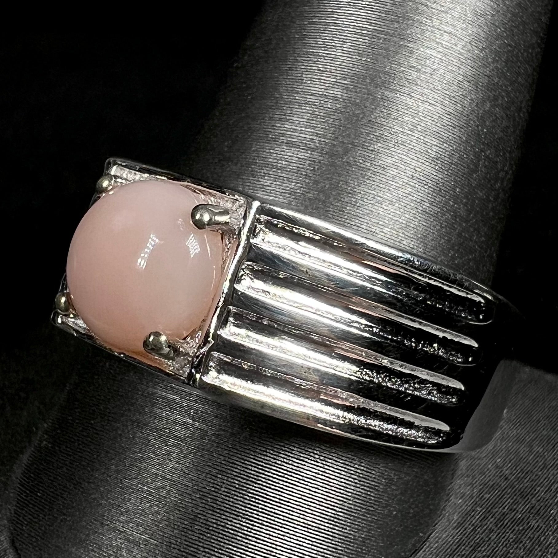 Close-up of size 12 pink opal men's ring in sterling silver on ring display
