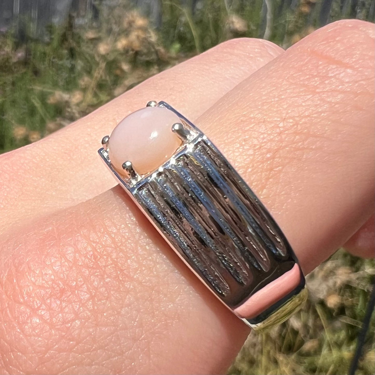 Size 12 sterling silver pink Peruvian opal ring worn on finger in natural sunlight