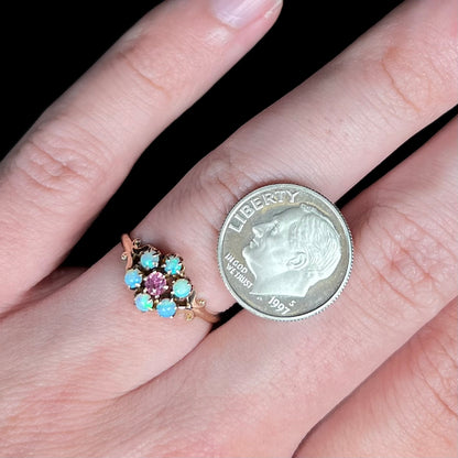 Small antique opal and pink tourmaline women's ring, worn on hand next to US dime coin for scale