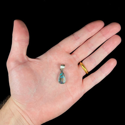 A handmade, satin finish sterling silver pendant set with a drop shaped boulder opal stone.