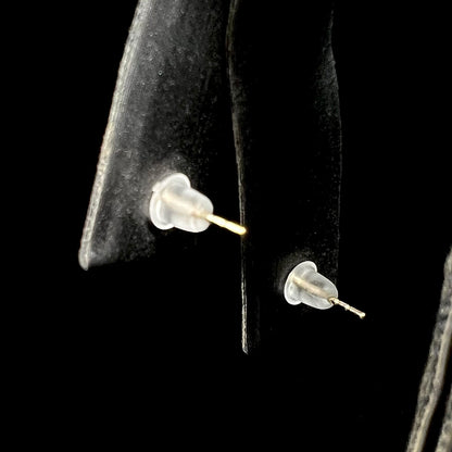 Back side of a pair of stud earrings on earring display; their 14k yellow gold push-back posts with rubber backings in view.