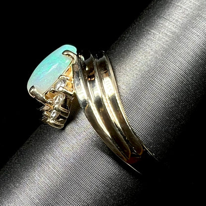 Side view of solid 14k yellow gold opal and diamond ring on ring display, focused on ring's shank